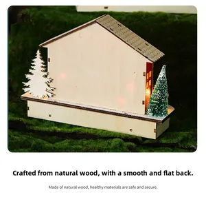 Macro detail of wooden Christmas house with LED warm light and miniature pine trees