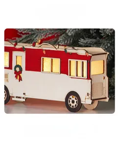 Close-up of wooden Christmas motorhome decor with glowing LED windows and festive wreath