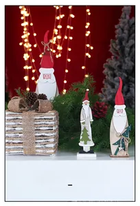 Gros plan de trois figurines de Père Noël en bois peint avec éclairage de fête chaleureux
