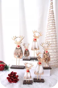 Detailed view of wooden Christmas reindeer figurines with faux fur and metal bells decor