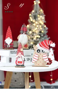 Detail view of four wooden Christmas gnomes and owl ornaments with plush textures