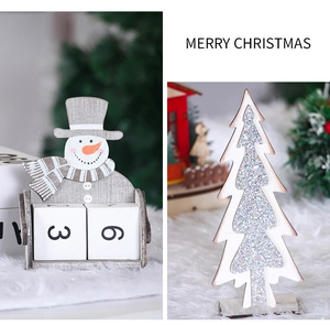 Close-up of wooden snowman countdown calendar and glittery Christmas tree desktop decor