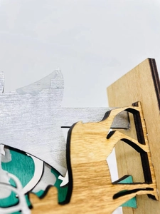 Macro shot showing multi-layer laser-cut wood textures and slotted assembly detail
