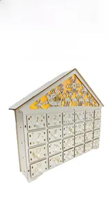 Detail of wooden Christmas advent calendar with 24 gold numbered drawers and warm lights