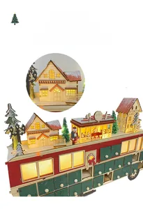 Close-up of lighted cabins and trees on red wooden Christmas bus advent calendar