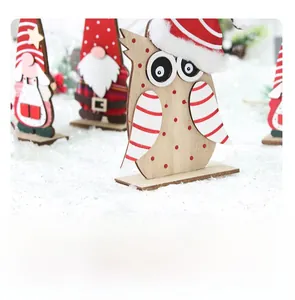 Detail of wooden Christmas gnome and owl figurines with fuzzy hats on faux snow