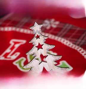 Detailed view of wooden Christmas tree decor with silver glitter and star cutouts