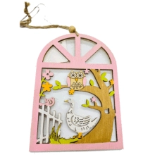 Close-up of pink wooden Easter ornament featuring laser-cut owl and floral scenery