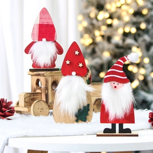 Three wooden Christmas gnomes with white faux fur beards and colorful festive hats