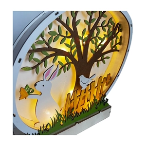 Detail of multi-layer wooden Easter bunny LED light with forest silhouette and warm glow