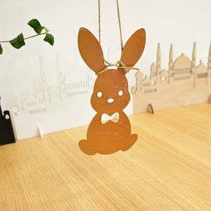 Macro view of vintage rusty metal rabbit pendant with jute rope for Easter home decor