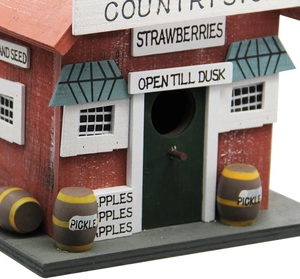 Detail of wooden birdhouse featuring Country Store signs and rustic hand-painted finish