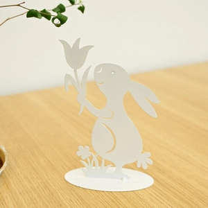 Minimalist white metal Easter bunny statue holding tulip flower on an oval base
