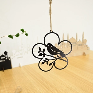 Close-up of rustic black metal bird silhouette in floral wreath with natural jute rope