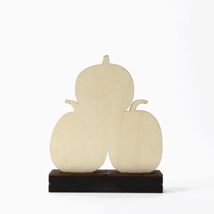 Close-up of stacked wooden pumpkin ornament with laser-cut edges and black base