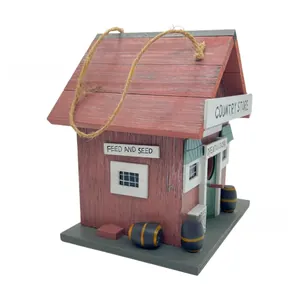 Close-up of red vintage wooden birdhouse with COUNTRY STORE text and hemp rope
