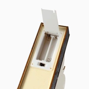 Detail view of the battery compartment and power switch on the wooden pumpkin ornament