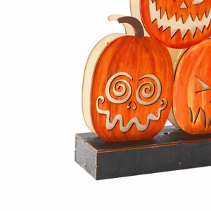 Lighted wooden Halloween pumpkin ornament with laser-cut faces on a black base