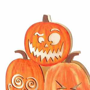 Detailed view of layered wooden Halloween pumpkins with carved spooky expressions