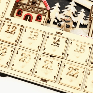 Macro shot of 24-day wooden Christmas advent calendar drawers with engraved numbers