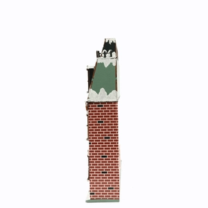 Detail of wooden lighted Christmas house with snowy green roof and red brick patterns