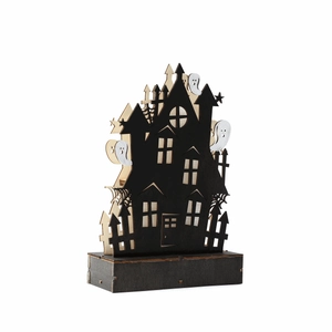 Macro detail of Halloween wooden haunted house decor with cutout ghosts and spider webs