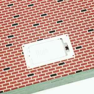 Detail view of the battery compartment and power switch on the Christmas house base
