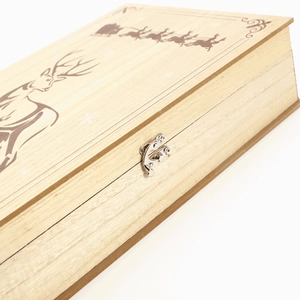 Close-up of wooden Christmas book box showing metal clasp and reindeer engraving