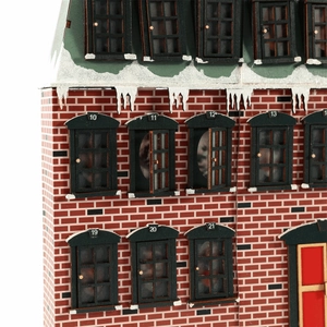 Wooden Christmas advent calendar house with red brick walls and glowing windows