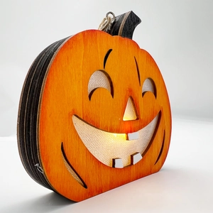 Detail einer Halloween Kürbis-Laterne aus Holz mit warmem LED-Licht und Gesicht