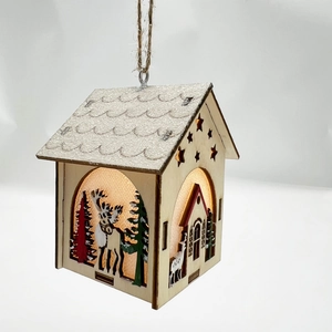 Gros plan d'une maison de Noël en bois avec lumière LED chaude et motifs de renne