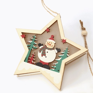 Close-up of star-shaped wooden Christmas ornament with snowman and tree hollow carving