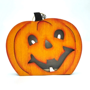 Detailansicht der ausgehöhlten Holzkürbis-Deko mit oranger Holzmaserung für Halloween