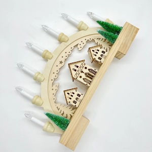 Macro view of wooden Christmas LED bridge with miniature carved houses and trees