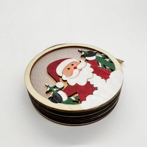 Macro detail of layered laser-cut wooden Santa ornament with festive red and green paint