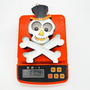 Nahaufnahme eines leuchtenden Halloween-Skelett-Anhängers auf einer Digitalwaage