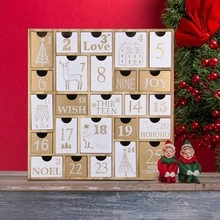 Macro detail of wooden Christmas advent calendar with 25 drawers and festive gold patterns