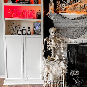 Halloween life-size skeleton with LED neon signs and spooky indoor party decorations