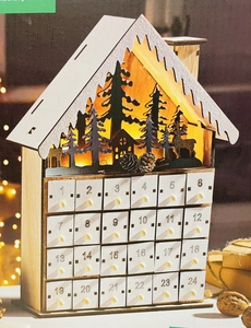 Close-up of wooden house advent calendar with 24 white drawers and LED reindeer forest scene