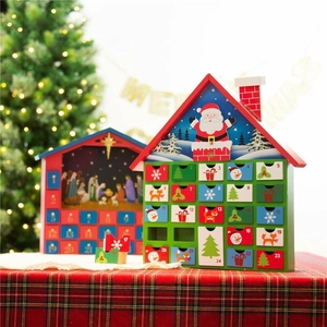 Wooden Christmas advent calendar house with 24 countdown drawers on a festive tabletop
