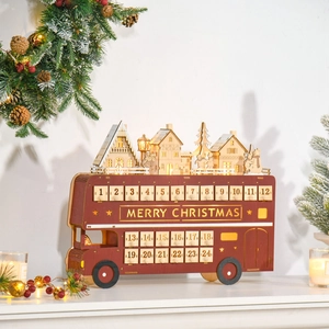 Detailed view of wooden Christmas bus advent calendar with LED glowing winter village scene