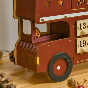 Close-up of wooden Christmas bus advent calendar with numbered drawers and red paint finish