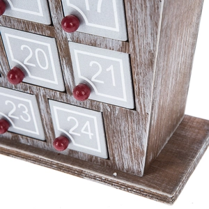 Close-up of wooden advent calendar drawers with red knobs and white numbers 17 to 24