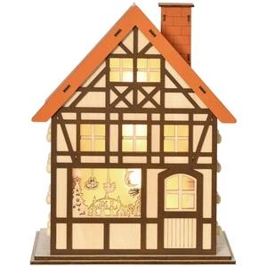 Close-up of wooden advent calendar house with warm LED lighting and miniature details