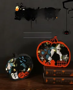 Détail de lampes citrouille d'Halloween en bois avec LED et scènes effrayantes découpées