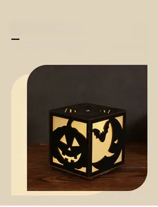 Close-up of laser-cut wooden pumpkin lantern with warm glowing Halloween patterns