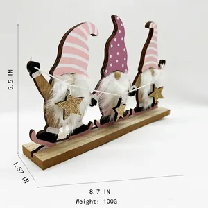 Trois gnomes de Noël en bois avec chapeaux roses et violets et étoile dorée sur socle