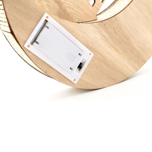 Detail view of the battery compartment and power switch on the wooden Moon LED light base