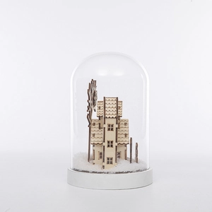 Détail d'une maison en bois et d'un moulin dans un dôme en verre avec décor de neige