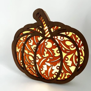 Detail view of multi-layered laser cut wooden pumpkin harvest LED light ornament